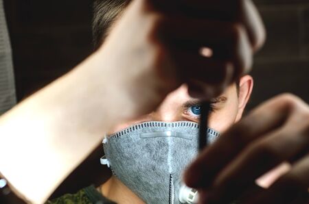 Young guy in a mask protecting against infection. Preventive measures against coronavirus infection. Close-up of a guy with a mask on his faceの写真素材