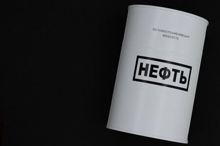 Barrel of oil on a black background. White barrel with inscriptions in Russian - "Oil" and "Flammable liquid"の写真素材