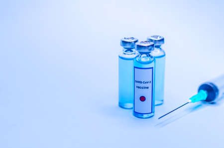 Coronavirus vaccine in glass vials on a blue background