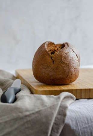 Sliced pieces of bread lying on a wooden board on a table with a cloth