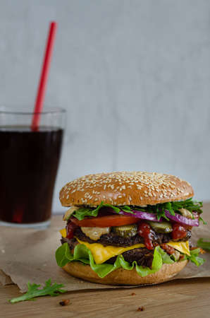 juicy powerful burger with beef and vegetables on a bun with sesame seedsの写真素材