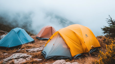 Vibrant tents sit in a misty mountain landscape, inviting adventure. This serene scene captures the essence of camping in nature's tranquility.の素材