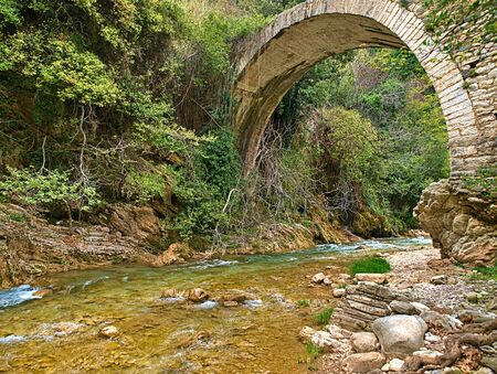 Traditional arch stone bridge above Neda river in Peloponnese, Greece.の写真素材