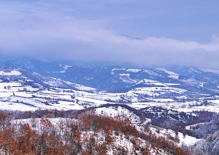 Mountain ridges, red trees and snow covered land. Winter landscape from Pieria, Greece.の写真素材