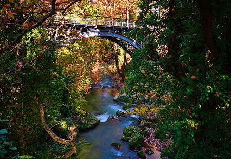 Long exposure photo, of beautiful river with trees and old metal bridge, Kalavryta Peloponnese, Greece.の写真素材