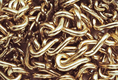 Tangled gold  chain close up. Textured metallic background.
