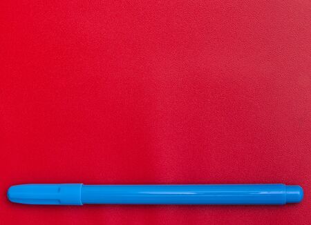 Blue marker isolated on red background, with empty space for text.の写真素材