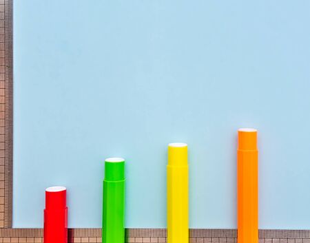 Colorful markers and rulers on light blue background, copy space for text, bar chart concept.の写真素材