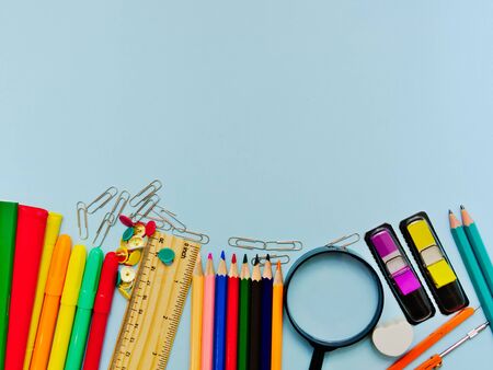 Colorful  school suplies against light blue background with copy space. Back to school concept, top view.の写真素材