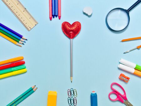 Colorful  school suplies in circle arrangement against light blue background with copy space.の写真素材