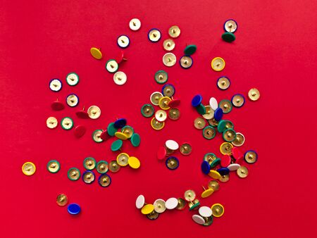 Colorful pushpins isolated on red background.の写真素材