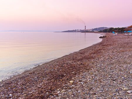 Beach at Kontari area, Chios island, Greece. Chimney of public electric power factory at the background.の写真素材