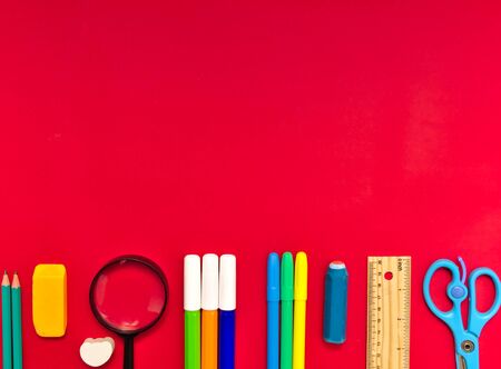 Colorful  school suplies on red  background with copy space. Back to school concept, top view.の写真素材