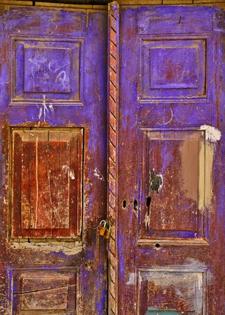 Detail of old aged stained wooden door with chain and padlocks.の写真素材