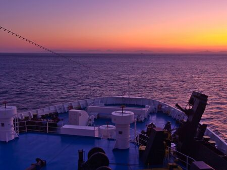 Ferryboat ship  bow with equipment while sailing in Aegean sea, Greece. Beautiful view from ship approaching land at sunset / sunrise time.の写真素材