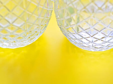 Two glass jars, pineapple shaped, against yellow background, natural light, selective focus.の写真素材