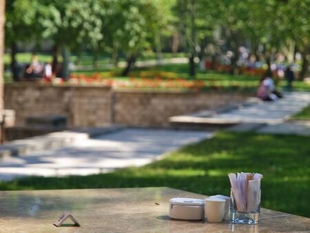 Cafe table detail and blurred park nature and people background with nice bokeh.の写真素材