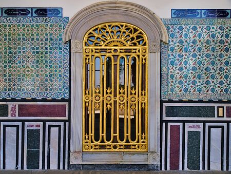 Window with golden railings and classical oriental design on tiled wall at Topkapi Palace in Istanbul, Turkey.のeditorial素材
