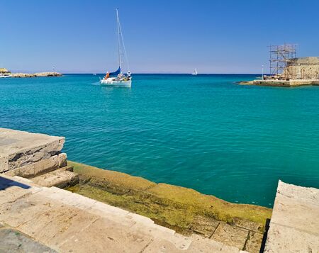 Rhodes island, Greece, - July 22, 2008: Sail boat entering Mandraki harbor, sunny summer day.のeditorial素材