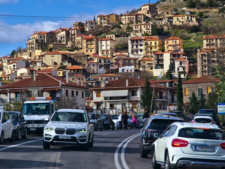 Arachova / Greece - December 28, 2019:  Village houses and street traffic under blue sky with clouds. Arahova cityscape.のeditorial素材