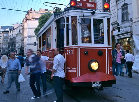 Istanbul / Turkey - May 25, 2010: Woman hanging on iconic vintage red tram vehicle that runs from Taksim to Tunnel.のeditorial素材