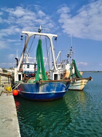 Seiner fishing ships with equipment in the port of Porto Lagos under blue sky with clouds.のeditorial素材