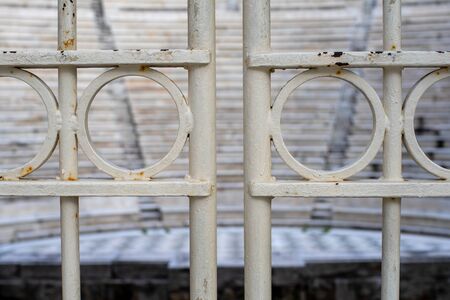 Metal door found at Odeon of Herodes Atticus entrance in Athens, Greece. Focus is on metal door, blurred theater in background.の写真素材
