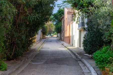 Athens / Greece  Narrow alley in Plaka Athens old town district. Sidewalk with plants and trees forming a gate.のeditorial素材