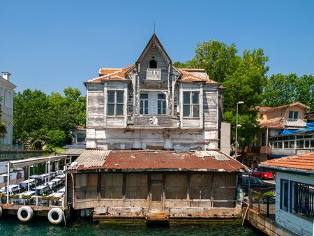 Yenikoy, Istanbul / Turkey -  Abandoned  old wooden mansion at Bosporus coast and restaurant yard beside it.の写真素材