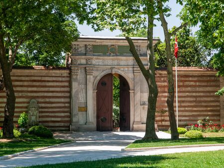 Inner  garden large door on fence wall, trees, flag and grass  Topkapi palace Istanbul, Turkey.のeditorial素材