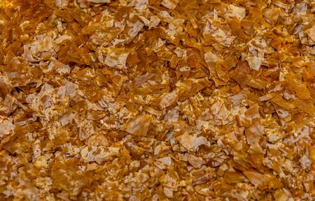 Shellac flakes, shellac is a  resin secreted by the female lac bug. It is dissolved in alcohol to make liquid shellac, which is used as a brush-on colorant, food glaze and wood finish.の写真素材
