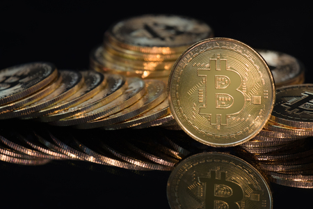 The golden Bitcoin is stacked on a black background, Conceptual image for worldwide crypto currency, huge stack physical version of golden Bitcoin.の写真素材