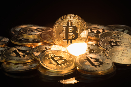 The golden Bitcoin is stacked on a black background, Conceptual image for worldwide crypto currency, huge stack physical version of golden Bitcoin.の写真素材