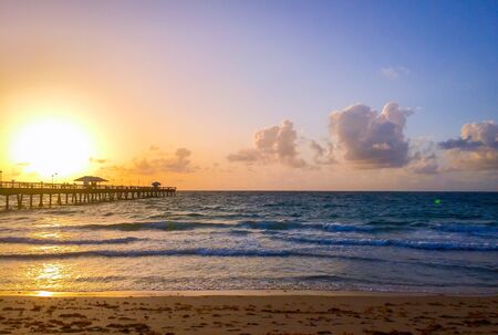 Pier and sunrise on the beach in colorful styleの写真素材