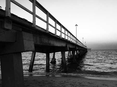 Walkway of the pier along to the ocean in black and white styleの写真素材