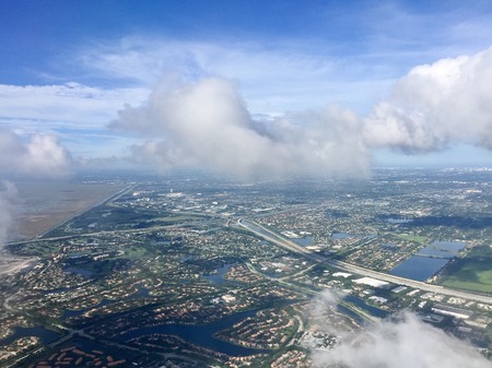 Town, road and river in aerial view from airplane with cloudy sky, Weston, Floridaの写真素材