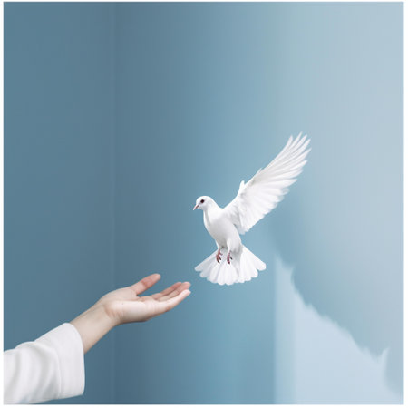 hand holding a white dove on a blue background, concept of peaceの素材