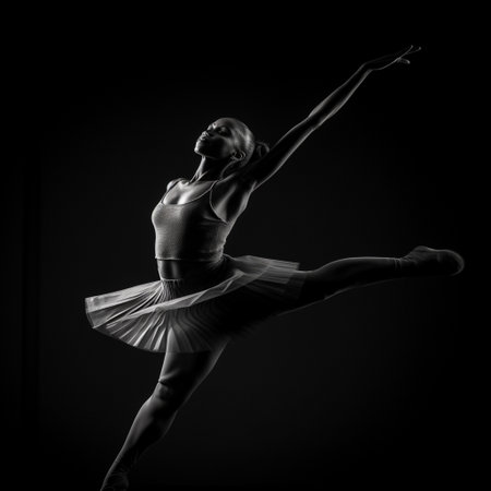Young beautiful ballerina is posing on a black background. Black and white photo.の素材