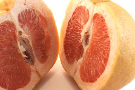 grapefruit cut into two equal parts on a white backgroundの写真素材