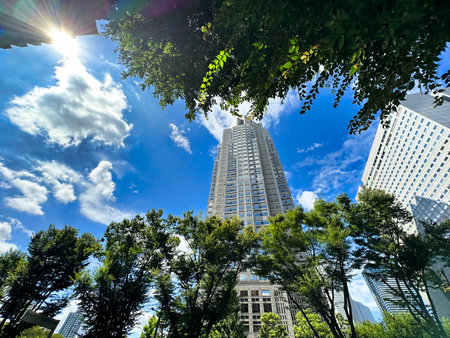 Tokyo Metropolitan Government Building, Shinjuku skyscrapers, blue sky, white clouds and greenery, daytimeの写真素材