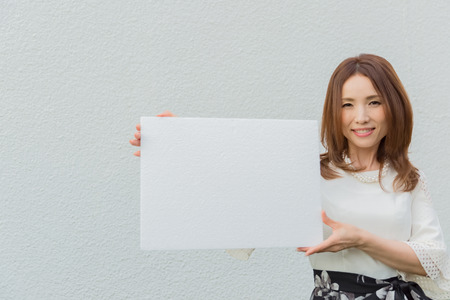 Lady holding blank white boardの写真素材