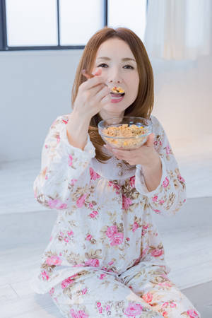 Lady in nightwear eating cerealsの写真素材