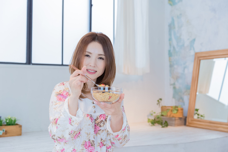 Lady in nightwear eating cerealsの写真素材