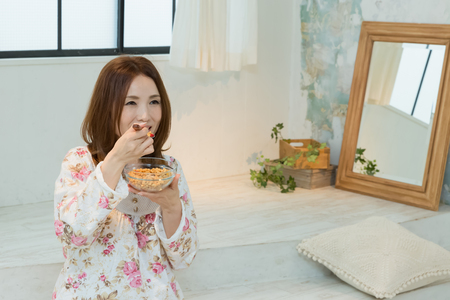 Lady in nightwear eating cerealsの写真素材