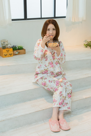 Lady in nightwear eating cerealsの写真素材
