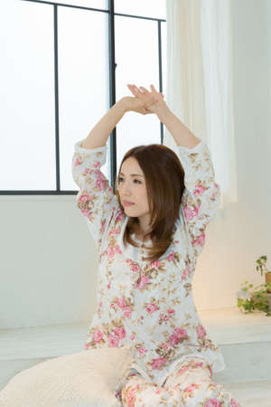 Lady in nightwear stretchingの写真素材