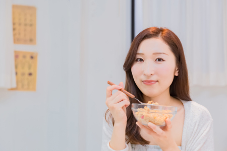 Lady in nightwear eating cerealsの写真素材