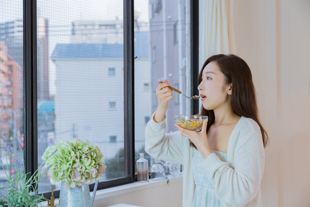 Lady in nightwear eating cerealsの写真素材