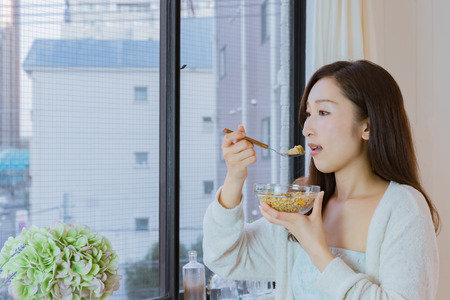Lady in nightwear eating cerealsの写真素材