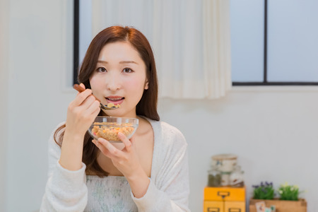 Lady in nightwear eating cerealsの写真素材